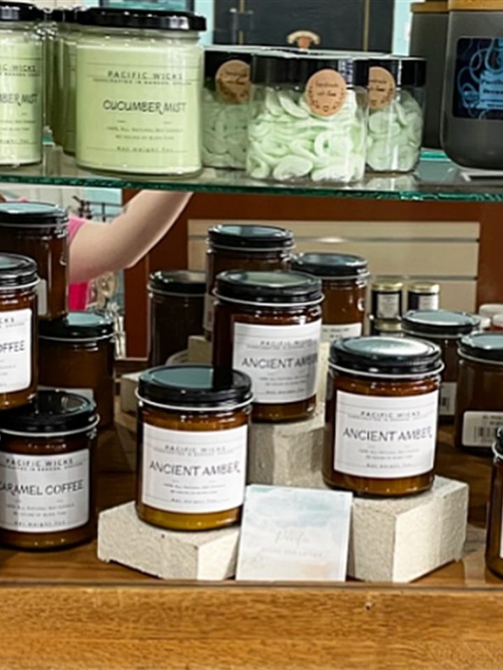 Shelf of Pacific Wicks amber jar candles in Cucumber Mist, Caramel Coffee, and Ancient Amber