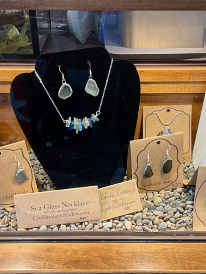 Display case of sea glass necklaces and earrings on kraft cards